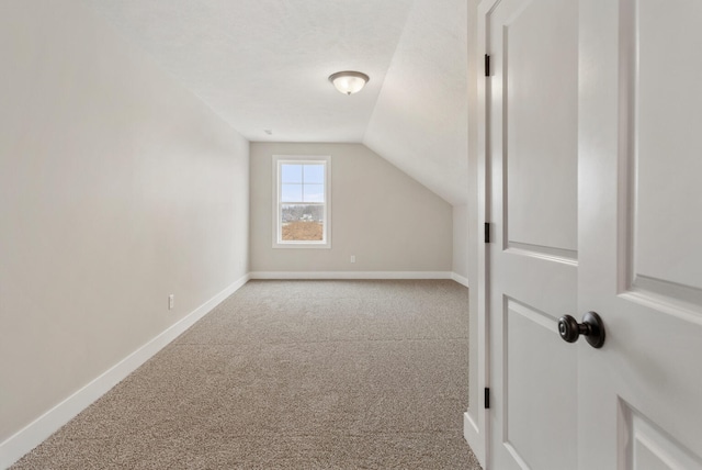 additional living space featuring vaulted ceiling and carpet