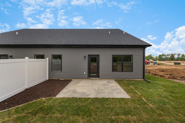 back of house with a lawn and a patio