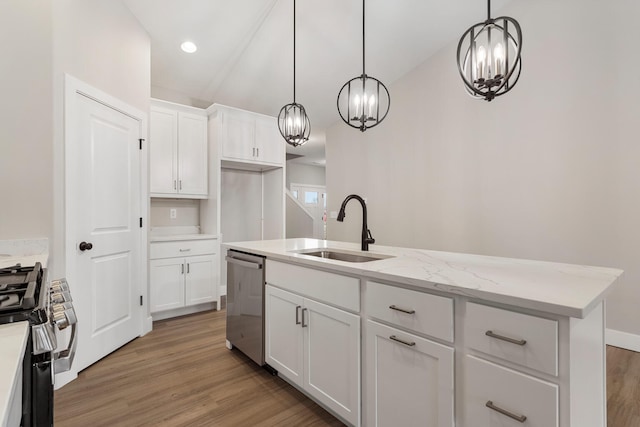 kitchen featuring pendant lighting, appliances with stainless steel finishes, an island with sink, sink, and light hardwood / wood-style flooring