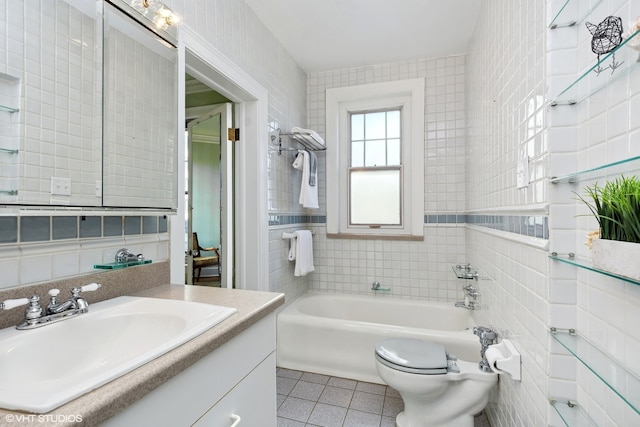 bathroom featuring tile walls, vanity with extensive cabinet space, tile floors, and toilet