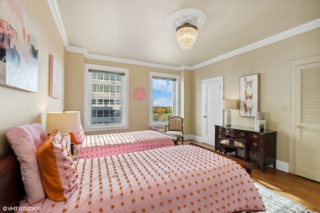 bedroom featuring an inviting chandelier, hardwood / wood-style floors, and crown molding