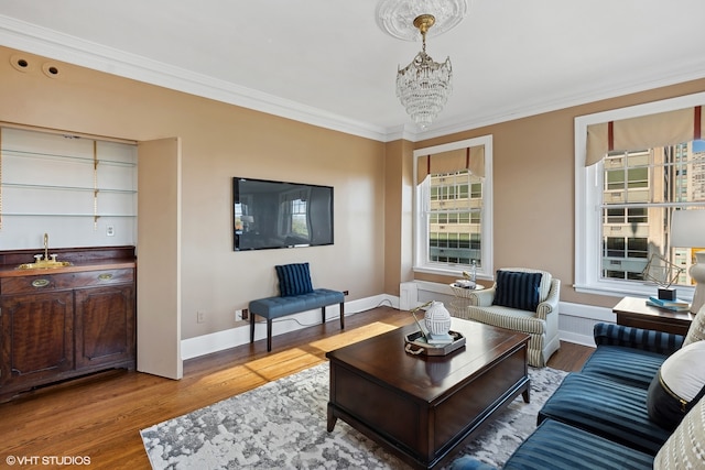 living room featuring a chandelier, light hardwood / wood-style flooring, and crown molding