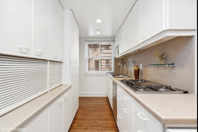 kitchen with dark hardwood / wood-style flooring, white cabinetry, stainless steel gas stovetop, and sink