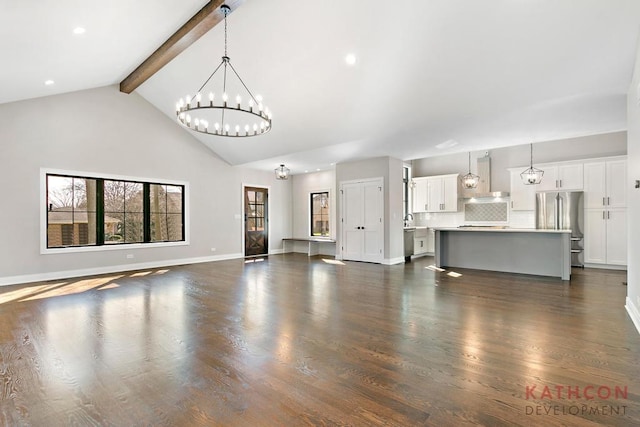 unfurnished living room featuring high vaulted ceiling, beamed ceiling, dark hardwood / wood-style floors, sink, and a notable chandelier