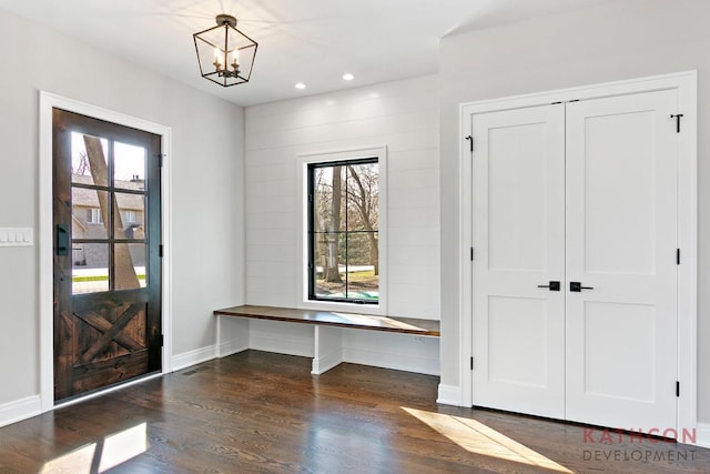 entryway with an inviting chandelier and dark hardwood / wood-style flooring