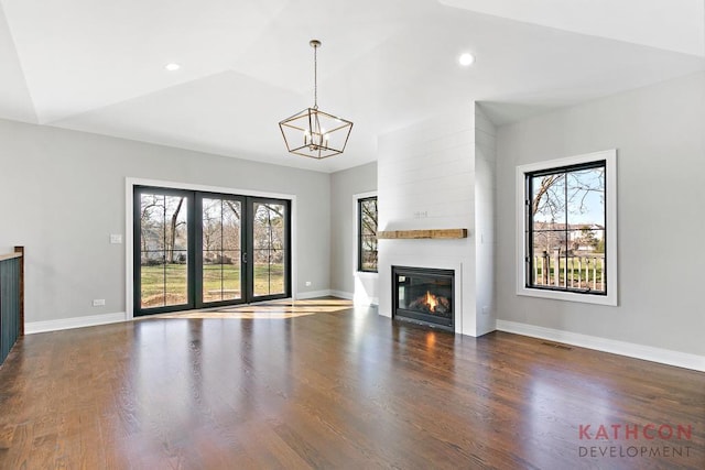 unfurnished living room with a fireplace, a wealth of natural light, and dark hardwood / wood-style flooring