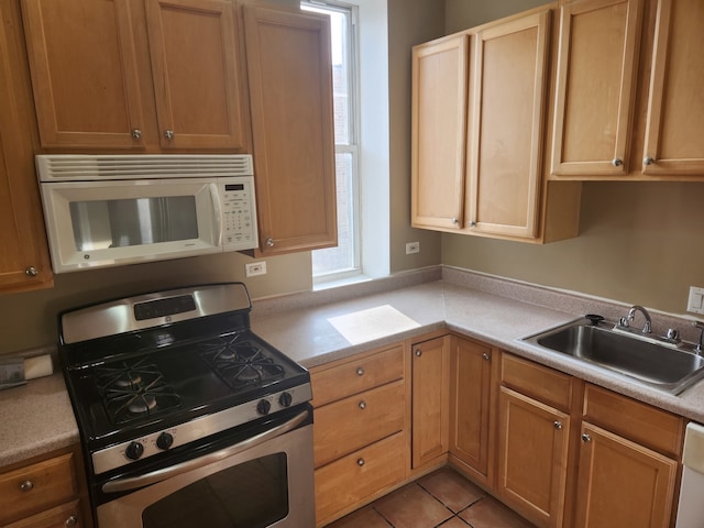 kitchen featuring sink, white appliances, and light tile patterned flooring