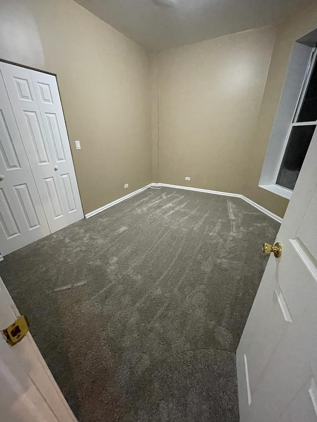 spare room with dark carpet