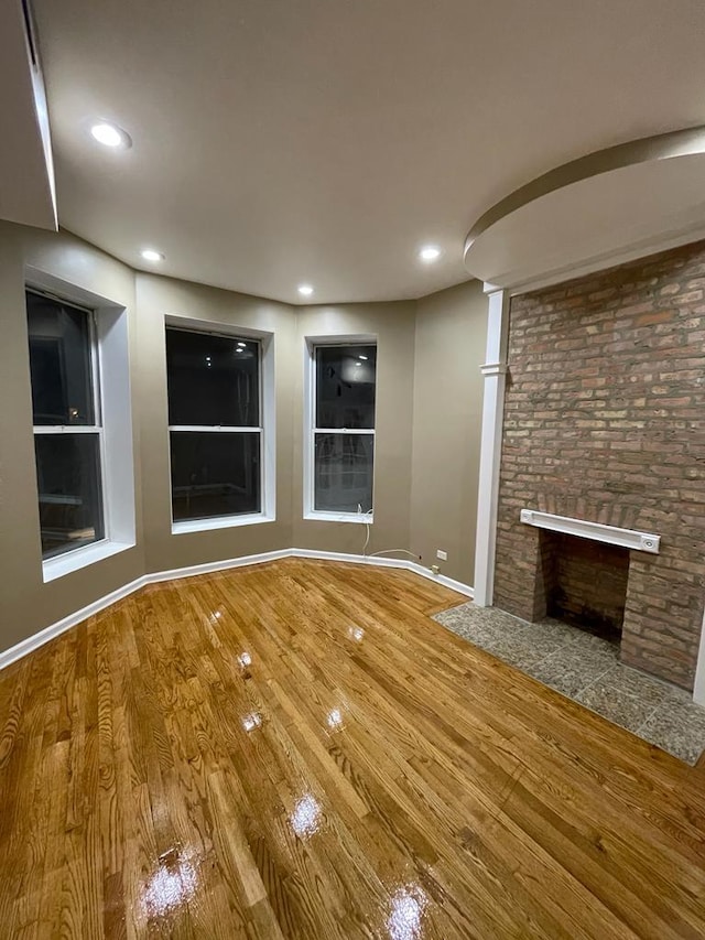 unfurnished living room with hardwood / wood-style floors and a fireplace