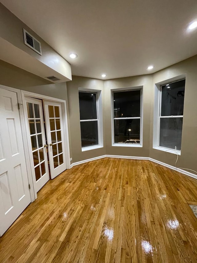 empty room with french doors and light hardwood / wood-style floors