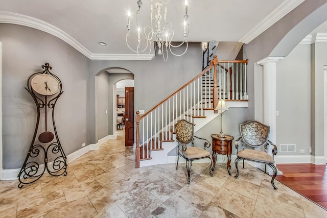 interior space featuring a notable chandelier, ornate columns, and crown molding