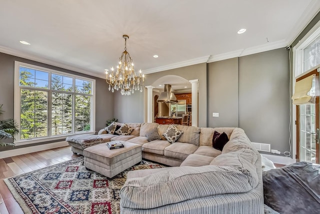 living room with a chandelier, hardwood / wood-style flooring, and crown molding