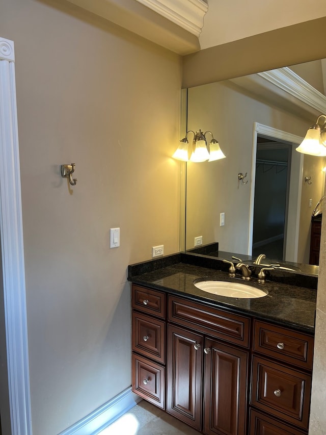 bathroom with ornamental molding and vanity with extensive cabinet space