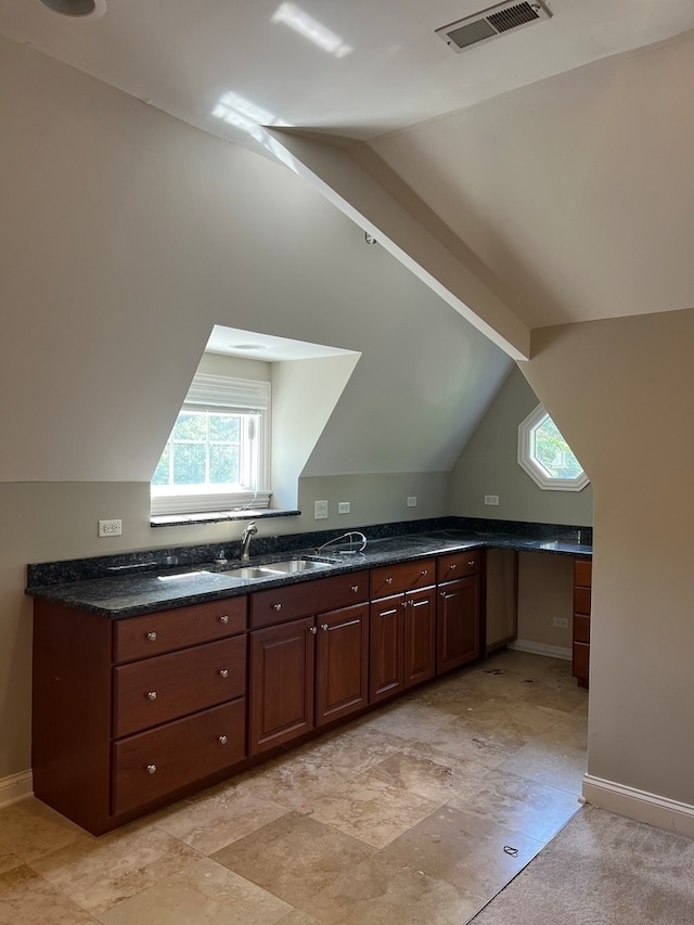 interior space featuring sink, vaulted ceiling, and light tile floors