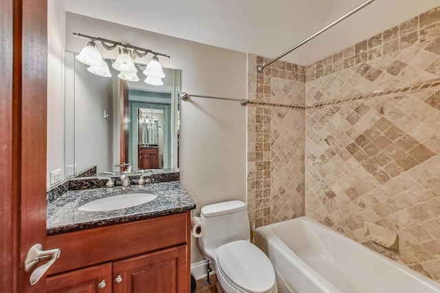 full bathroom with tiled shower / bath combo, large vanity, and toilet