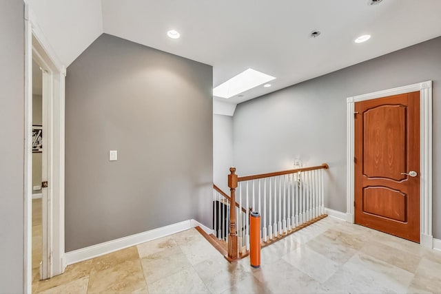 foyer featuring light tile flooring and a skylight