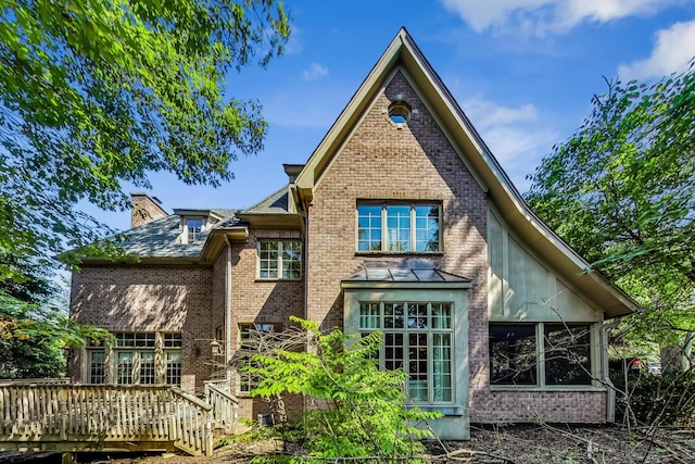 back of property with a sunroom and a deck