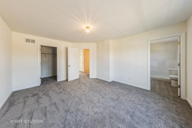 unfurnished bedroom with a closet, visible vents, ensuite bathroom, carpet flooring, and baseboards