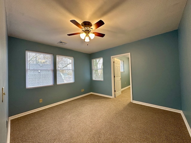 empty room with light carpet, ceiling fan, and a wealth of natural light