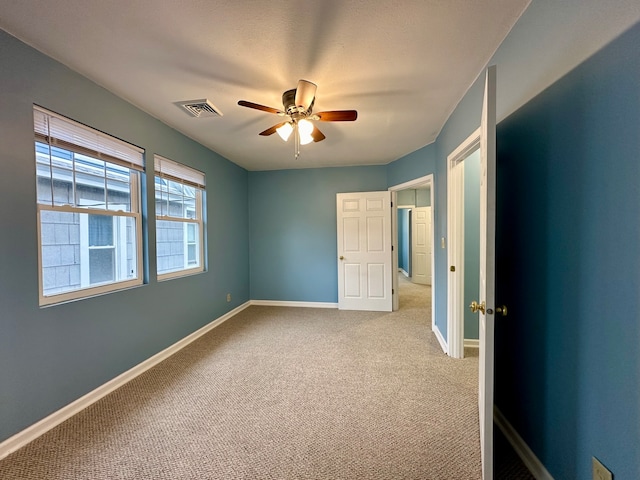 unfurnished bedroom with light colored carpet and ceiling fan