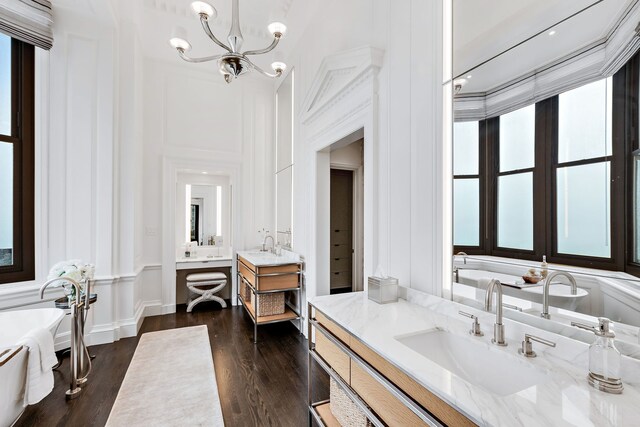 159 E Walton Pl Unit Ph, Chicago, IL 60611 - full bath featuring a decorative wall, two vanities, a freestanding bath, a chandelier, and wood finished floors