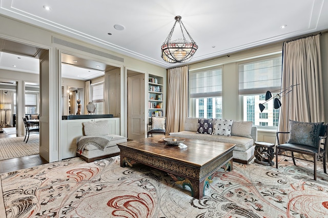 living room featuring built in features, wood-type flooring, and ornamental molding