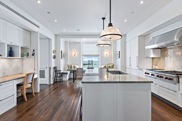 kitchen with stainless steel gas cooktop, a sink, ornamental molding, ventilation hood, and built in study area