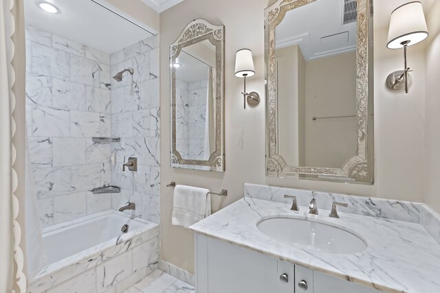 bathroom with visible vents, marble finish floor, tiled shower / bath combo, and vanity