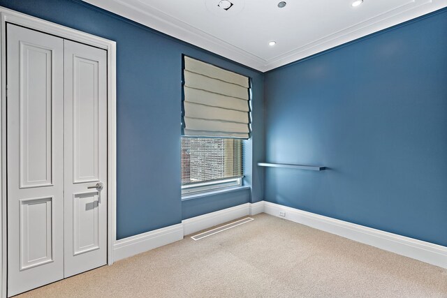 carpeted empty room featuring recessed lighting, visible vents, crown molding, and baseboards