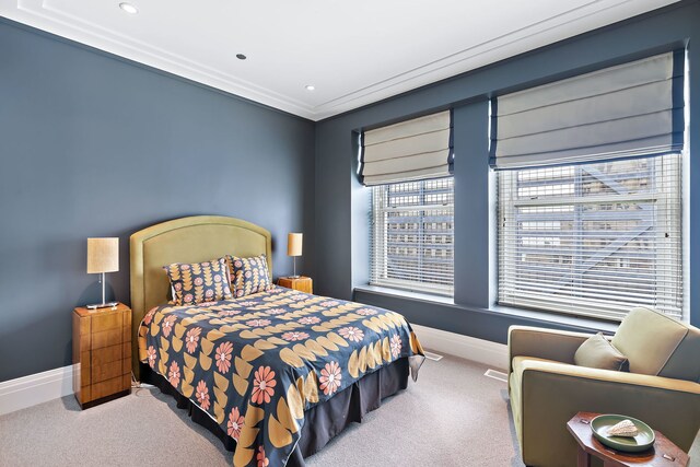 carpeted bedroom featuring crown molding and baseboards