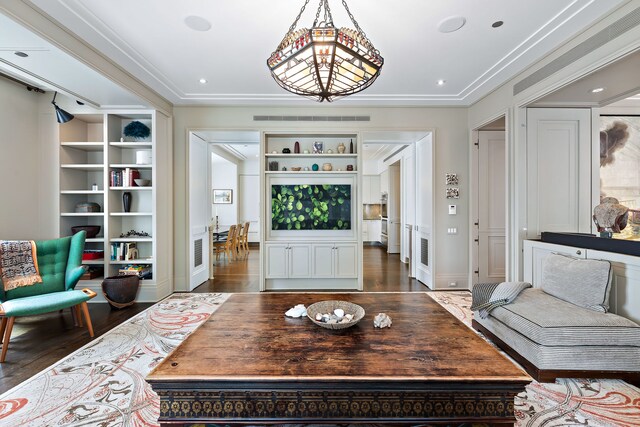 living area featuring built in features, crown molding, recessed lighting, visible vents, and wood finished floors