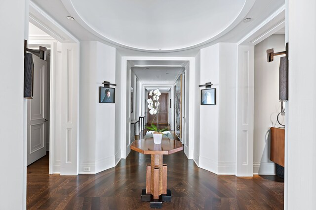 corridor with baseboards and wood finished floors