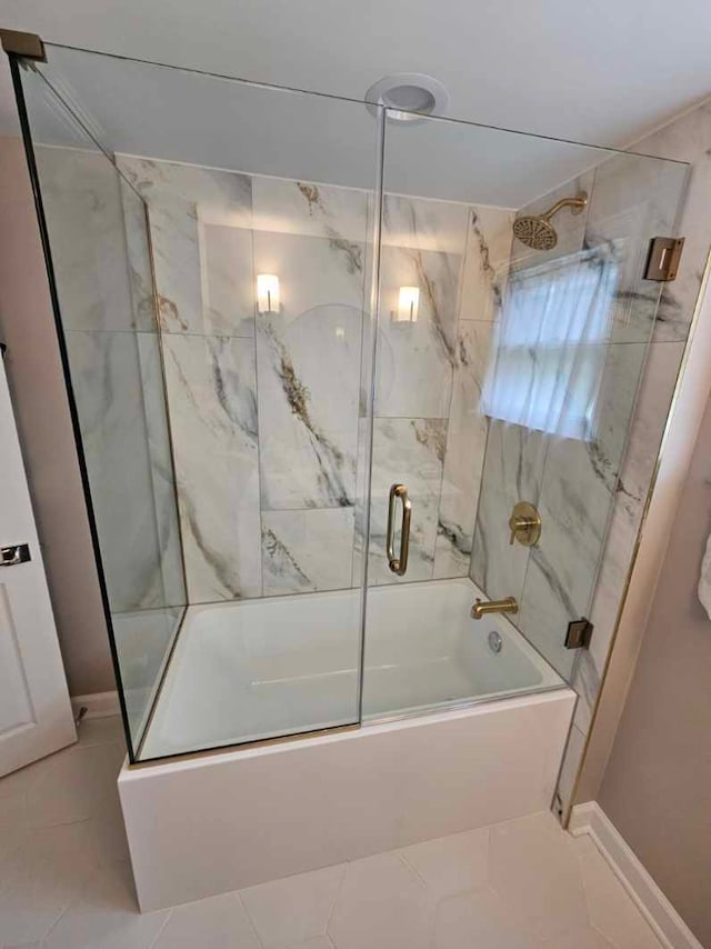 bathroom featuring tile patterned flooring and bath / shower combo with glass door