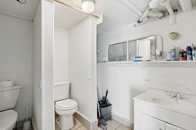 bathroom with toilet, tile patterned flooring, and vanity