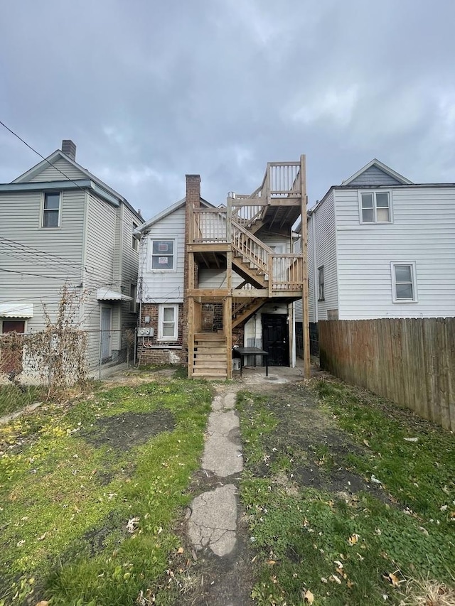 rear view of property featuring a lawn