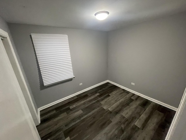 unfurnished room with dark wood-type flooring