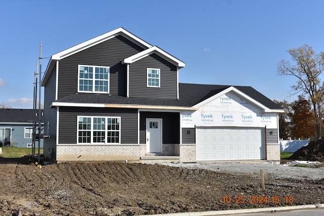 view of front facade featuring a garage, driveway, and brick siding