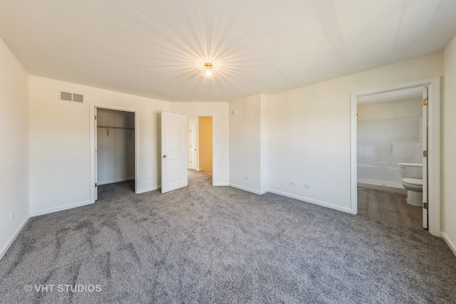 unfurnished bedroom featuring connected bathroom, carpet floors, and a closet