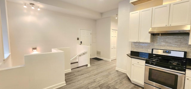 kitchen featuring white cabinets, light hardwood / wood-style floors, stainless steel range with gas cooktop, and tasteful backsplash