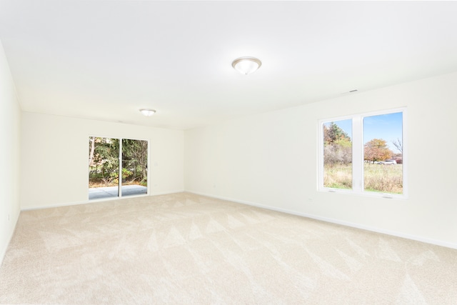 spare room featuring light carpet and a healthy amount of sunlight