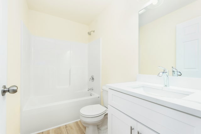 full bathroom with shower / tub combination, vanity, wood-type flooring, and toilet