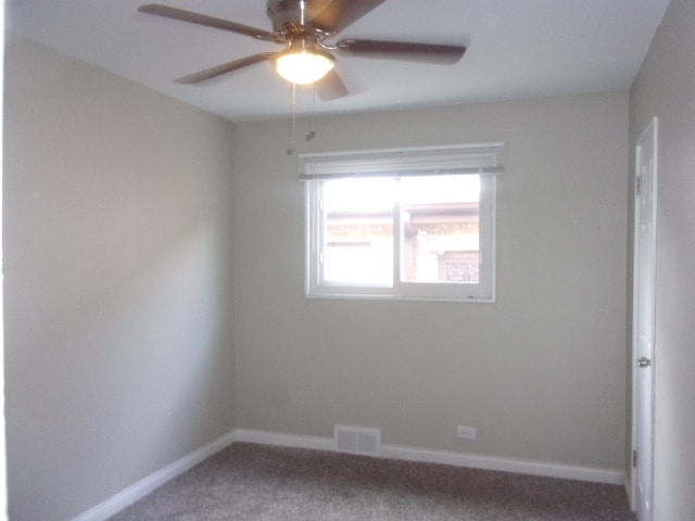 spare room featuring ceiling fan and carpet floors