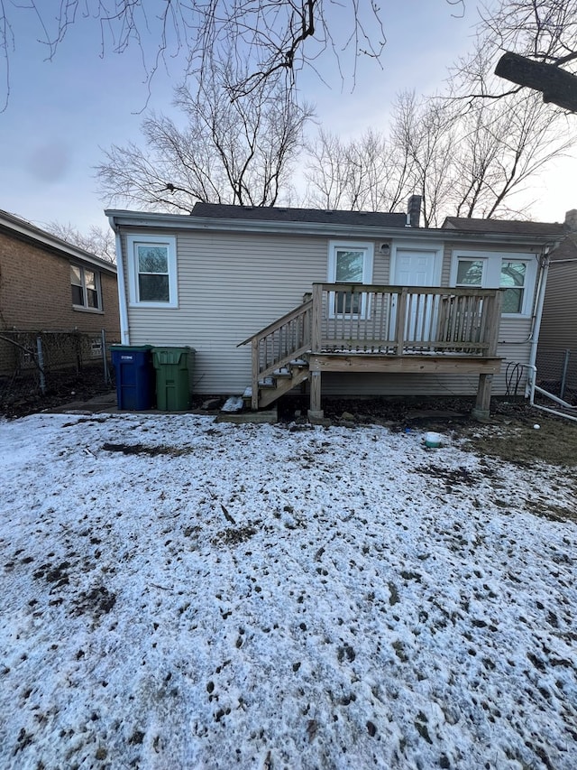 snow covered house featuring a wooden deck