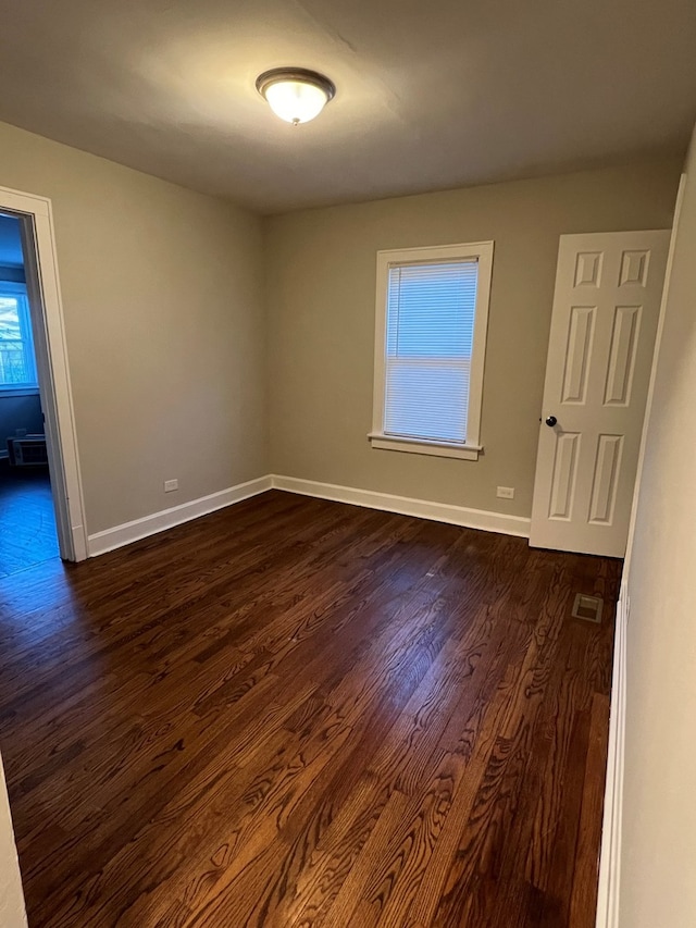 spare room with dark wood-type flooring