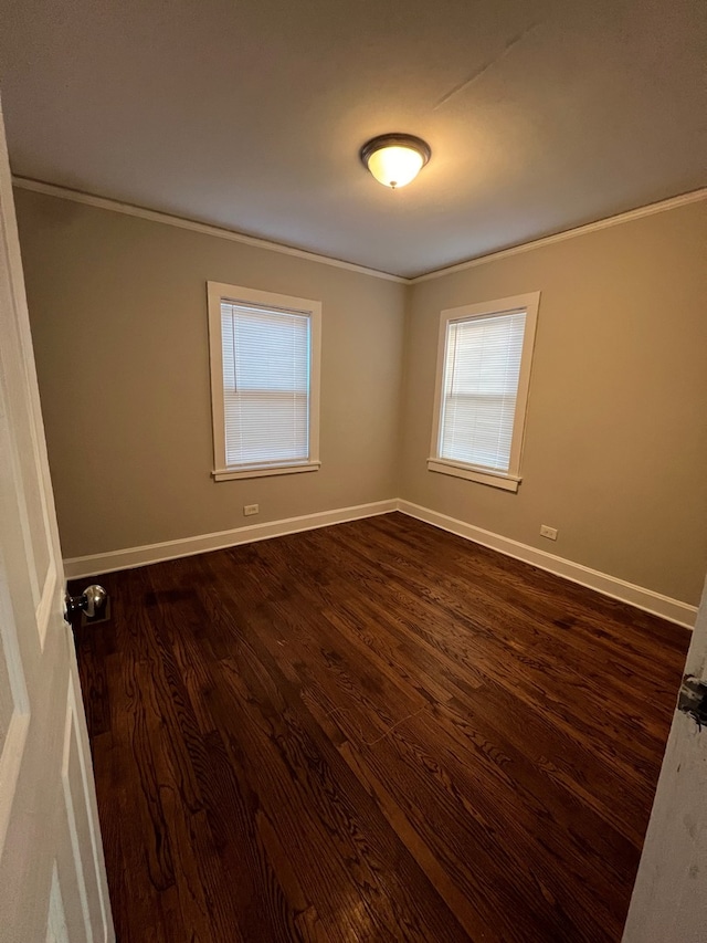 unfurnished room with dark wood-type flooring and ornamental molding