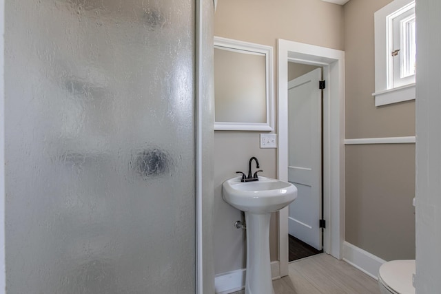 1011 5th St, Mendota, IL 61342 - bathroom featuring a shower stall, toilet, wood finished floors, baseboards, and a sink