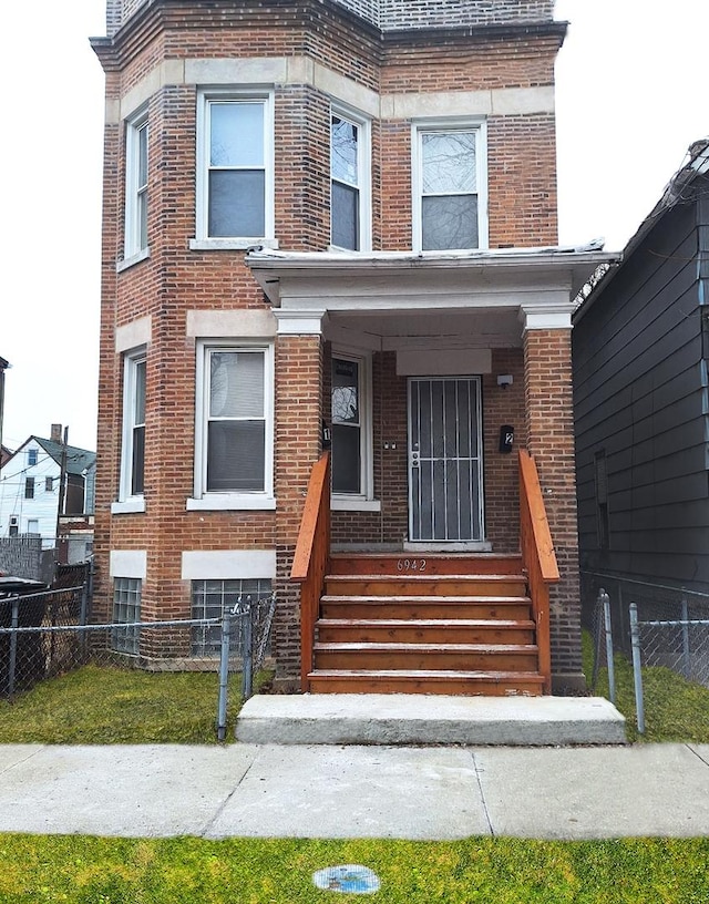 view of front of property featuring brick siding and fence