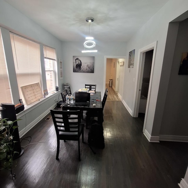 dining area featuring baseboards and dark wood-style floors