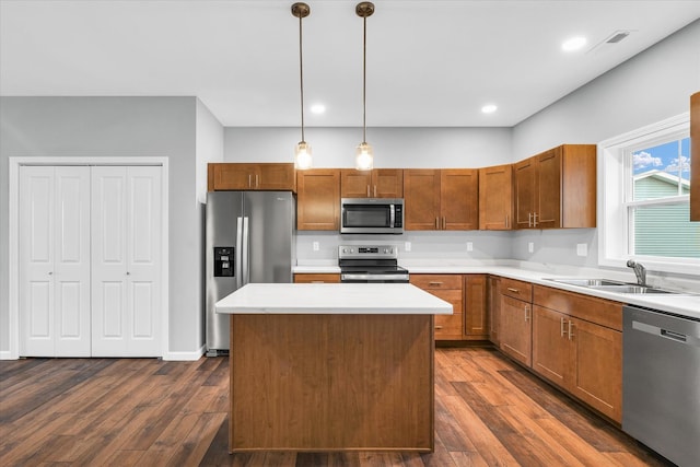 kitchen featuring pendant lighting, dark hardwood / wood-style flooring, sink, and appliances with stainless steel finishes