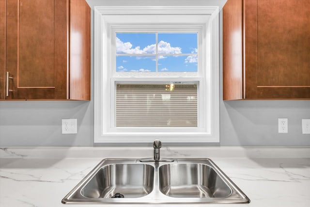 kitchen featuring light stone countertops and sink